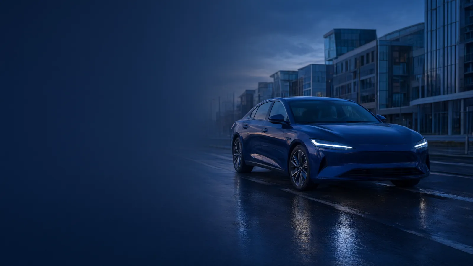 Voorkant van een donkerblauwe auto in een stadsstraat bij avond